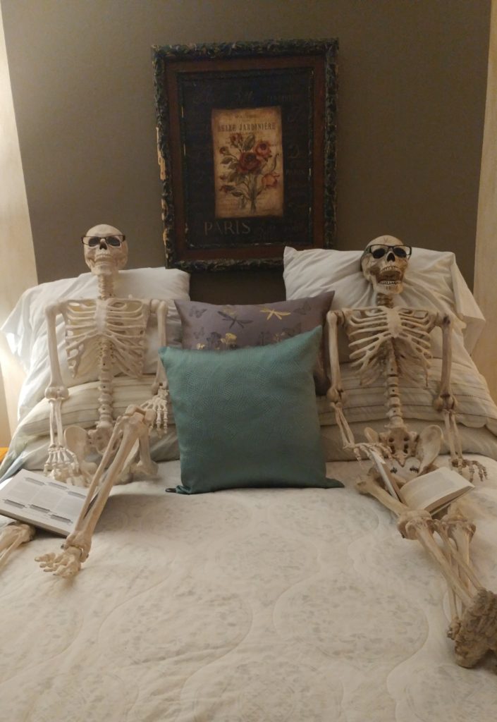 2 skeletons reading.